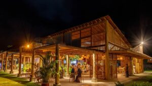 Casa de festa da Bisutti em estilo rústico-chique à noite, com estrutura de madeira, iluminação aconchegante e convidados reunidos em ambiente sofisticado.