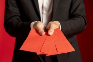 Homem de terno segurando convite de evento corporativo.